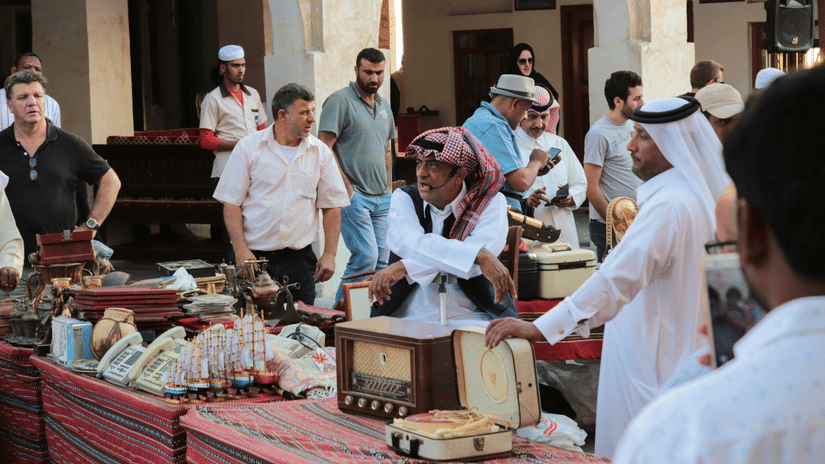 A vibrant Souq Waqif in Qatar with people moving from one stall to another shopping.