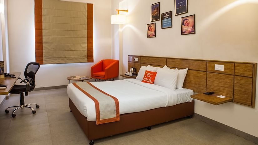A side view of comfy room with study table and a comfy sofa. | Max Hotel Prayagraj