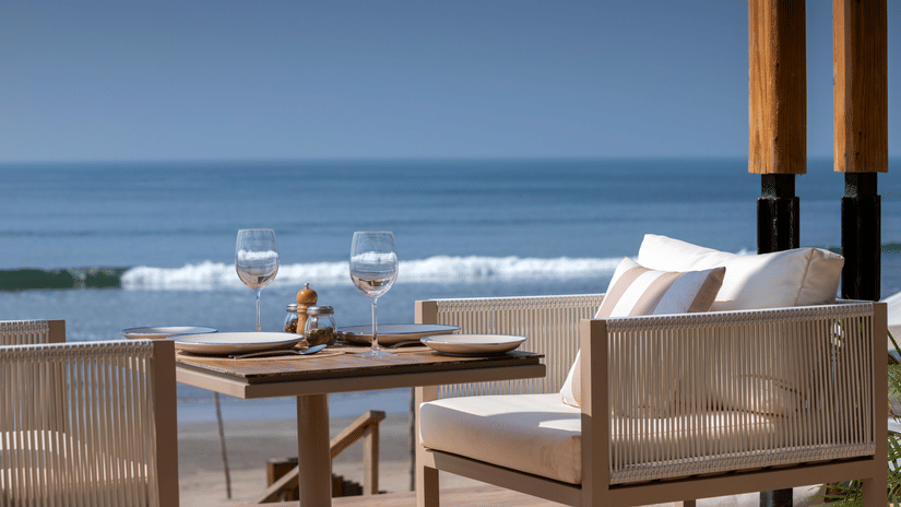 close up image of a chair with white cushion with a serene background of blue ocean