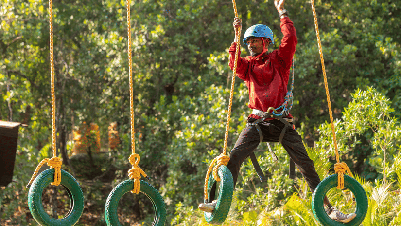 Image of a person on a high rope course platform. | Stone Wood Jungle Resort, Dandeli