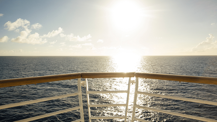 brown and white railing of a cruise ship overlooking the ocean