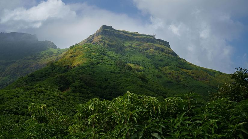 View of a mountain with cloudy sky in the background.