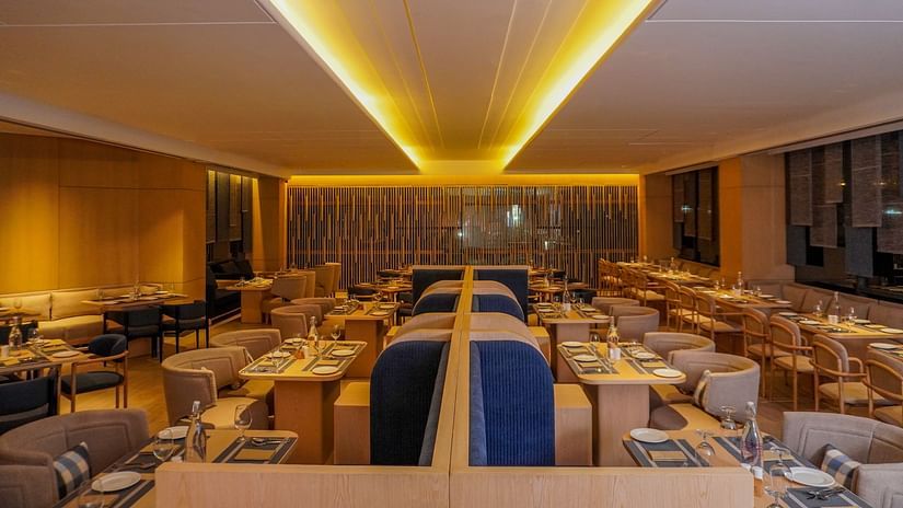 Contemporary restaurant design features striking angled ceiling lights and neatly arranged tables with settings - The Orchid Hotel, Chandigarh