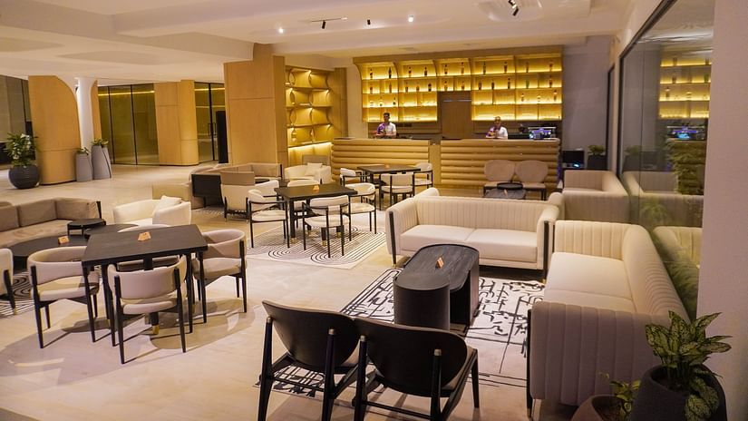 Alternative perspective of the hotel restaurant showcasing numerous tables, a well-stocked bar with warm lighting, and a relaxed yet sophisticated dining environment - The Orchid Hotel, Chandigarh