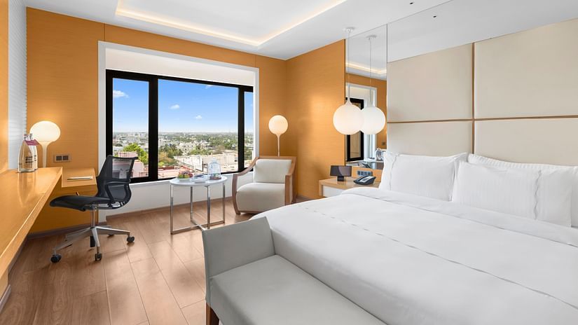 Club Room with a cozy king-sized bed, a work station, and a city view from the window at The Residency Towers Coimbatore.
