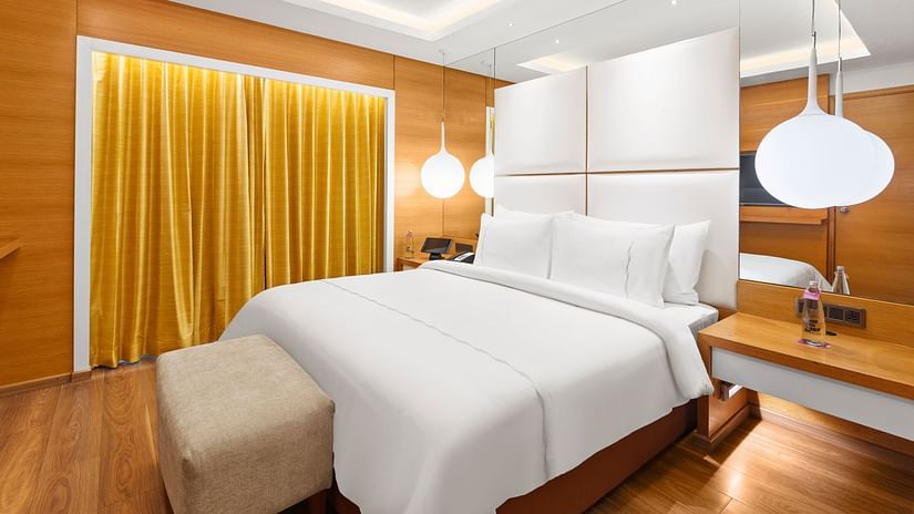 Club Suite room with a cozy bed and hanging bedside lights at The Residency Towers Coimbatore