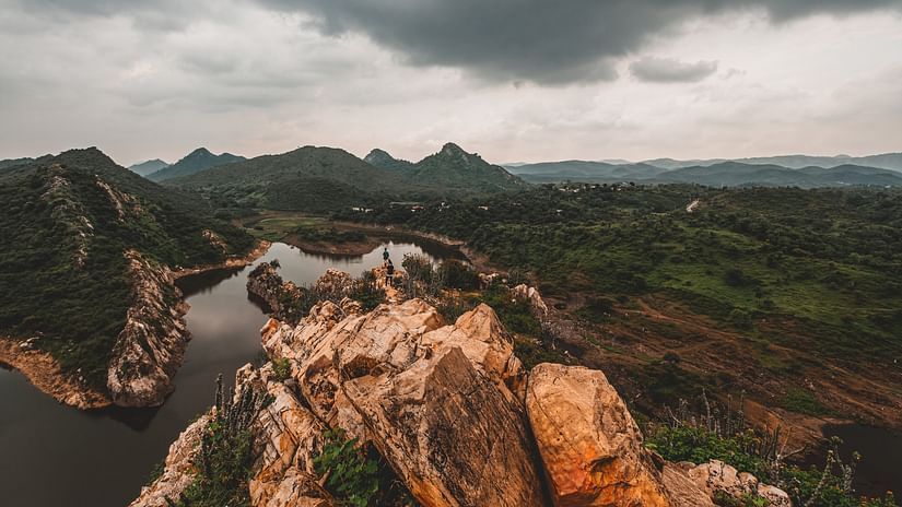 Nature with a small steam running on the left and greenery and hills in the background