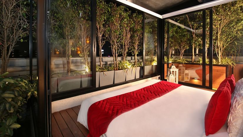 A cozy bedroom at night, featuring an open view of the starry sky, with soft lighting creating a warm and inviting atmosphere