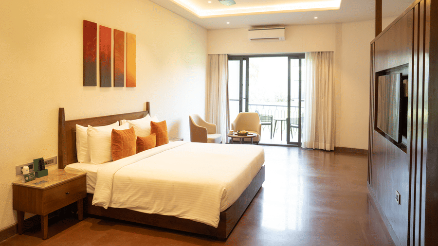 Duplicate of Spacious bedroom with wooden flooring, modern decor, and large glass doors opening to a sit-out at Ananta Spa and Resort, Ajabgarh.