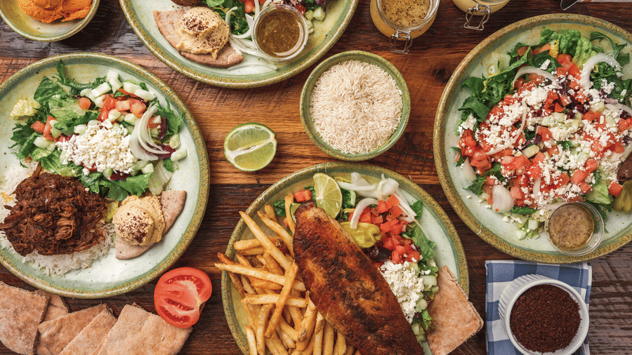 Overhead view of a table spread featuring multiple plated dishes and fries.