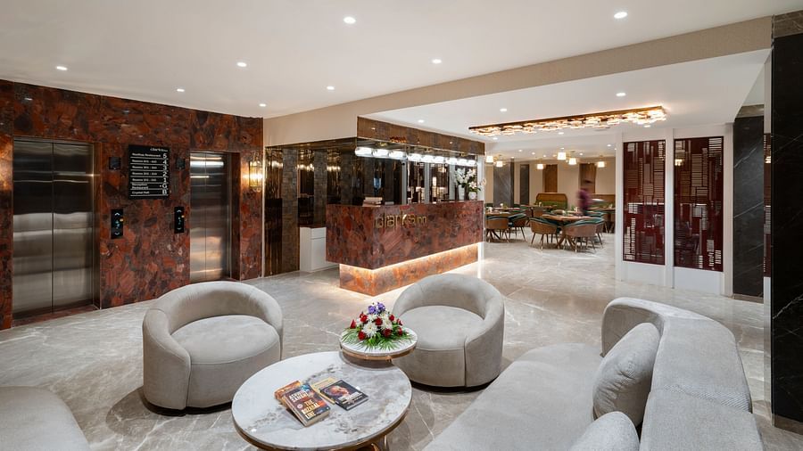 Upscale hotel lobby featuring a reception desk and a seating area with elevators - Clarks Inn, Indore