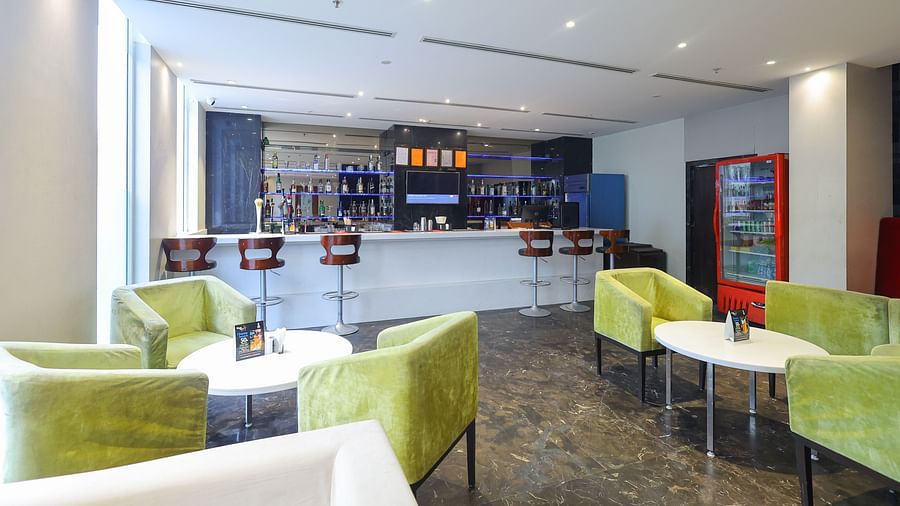 Front view of black velvet bar counter area with seating at Icon Premier Hotel by Bhagini, Devarabisanahalli