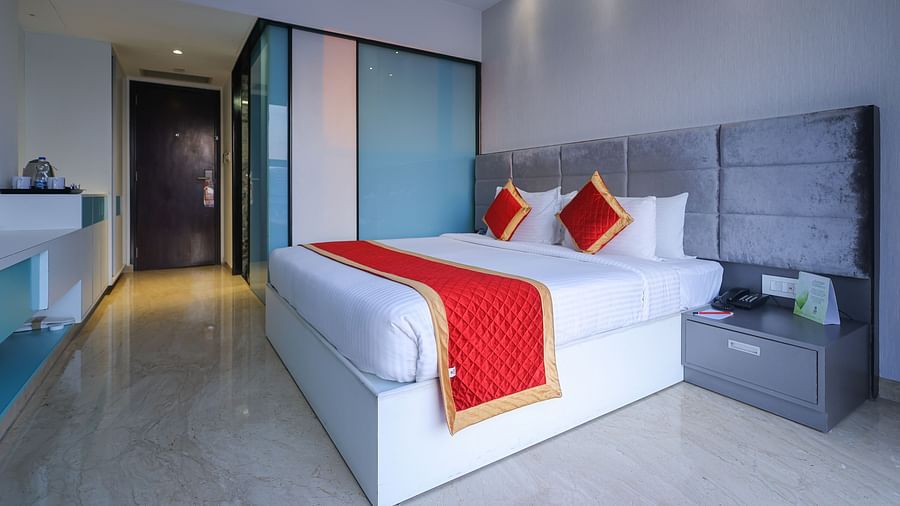 A cozy king-size bed and a wardrobe in the corner of the studio room at Icon Premier Hotel by Bhagini, Devarabisanahalli