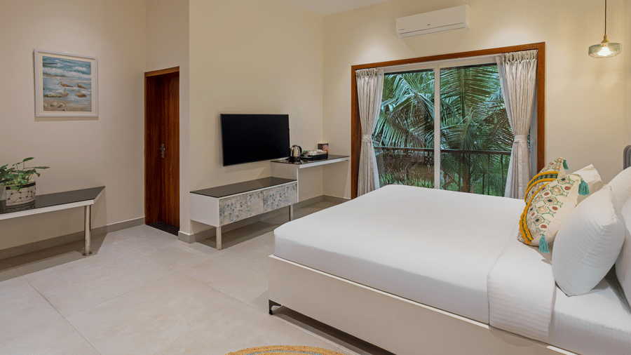 Deluxe room featuring cozy bed, TV unit, and modern interiors at Lamrin Morjim Goa.