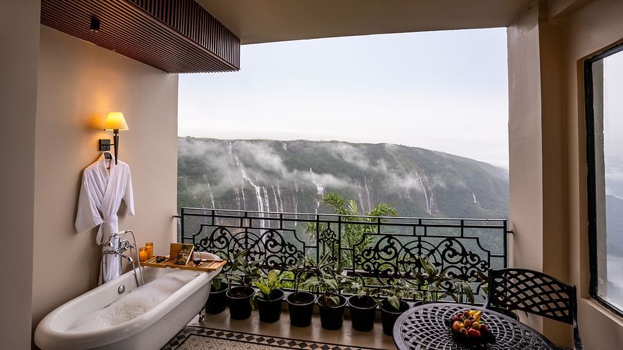 An image of  balcony with flower pots from where water falls can be seen - Polo Orchid Resort, Cherrapunjee