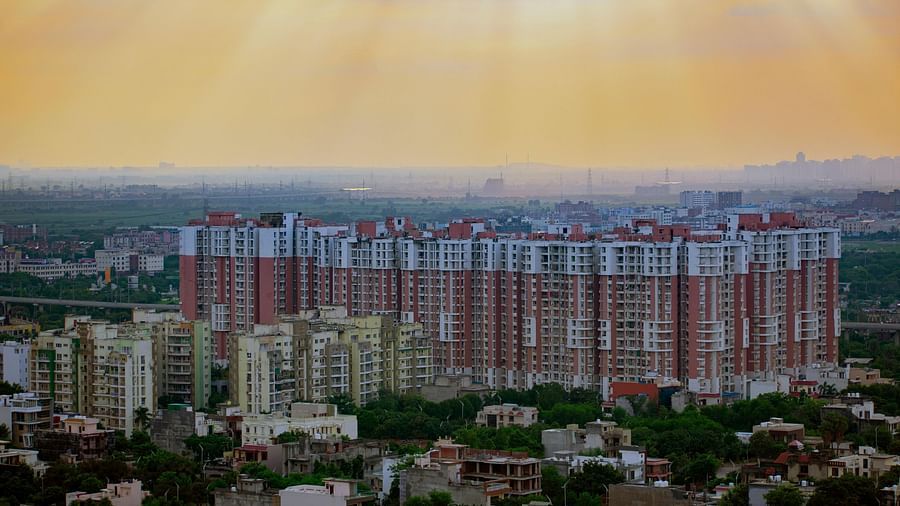 An image of multi storey buildings surrounded by small residential areas and trees