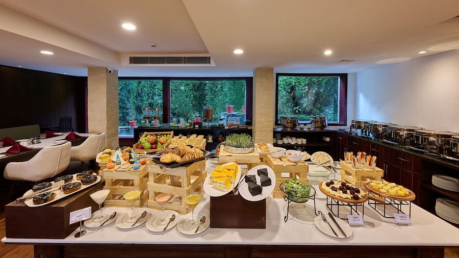 A wide variety of food laid on a restaurant serving counter - Renest Dunsvirk Court Mussoorie