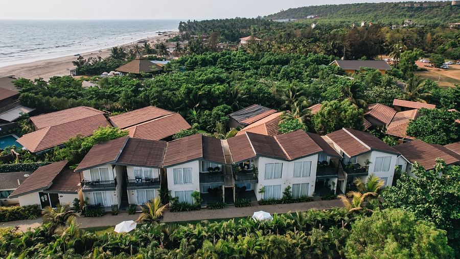 an aerial vie image of the facade of sibaya beach resort, morjim beach that is surrounded by lush tropical greenery