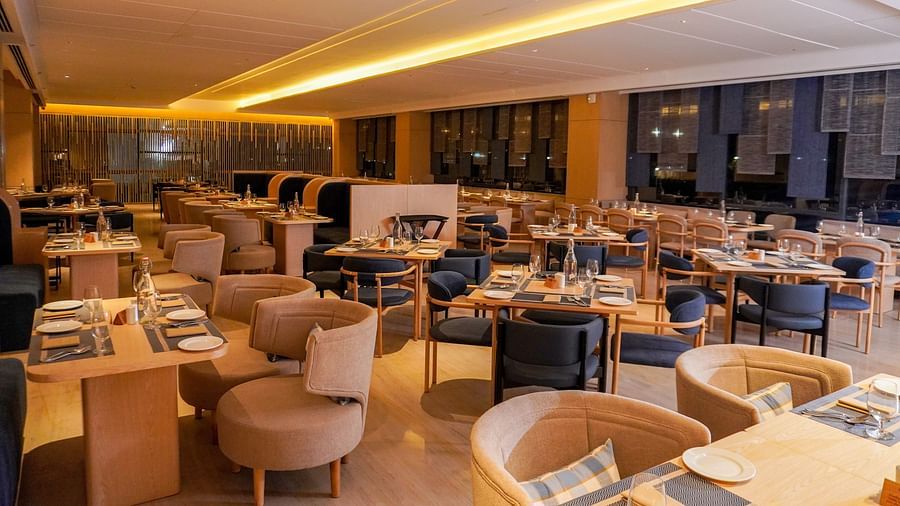 Expansive restaurant view shows soft overhead lighting, diverse seating with booths and tables, and a warm ambience - The Orchid Hotel Chandigarh 