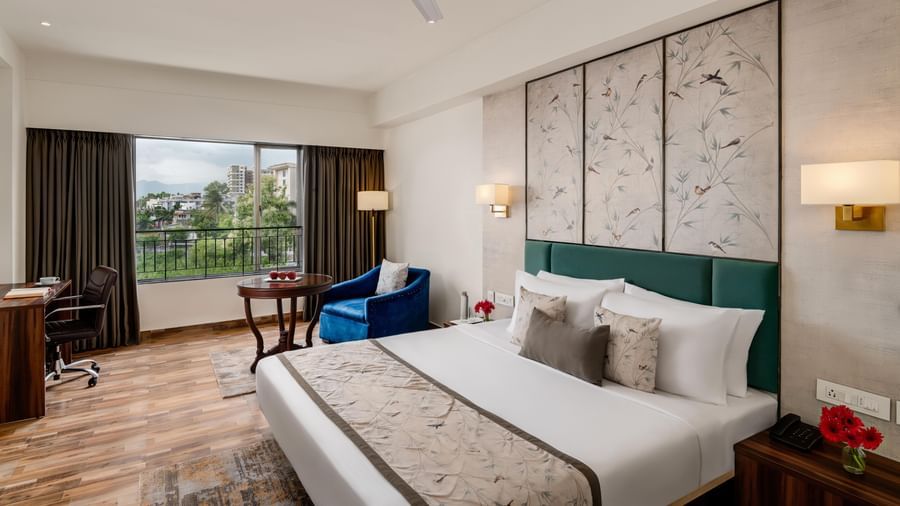 Comfortable room at Voyage Milestone Hotel and Banquet with seating area and balcony access.