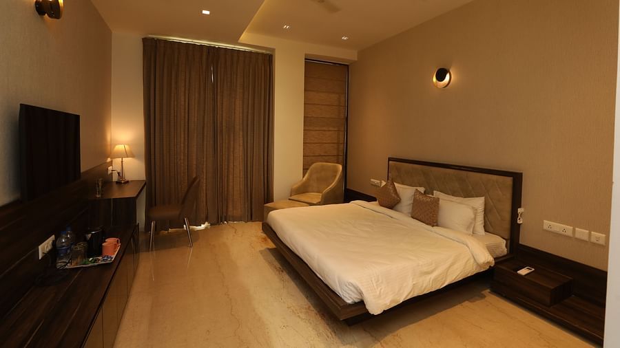 Hotel bedroom interiors with chairs television and a white king size bed