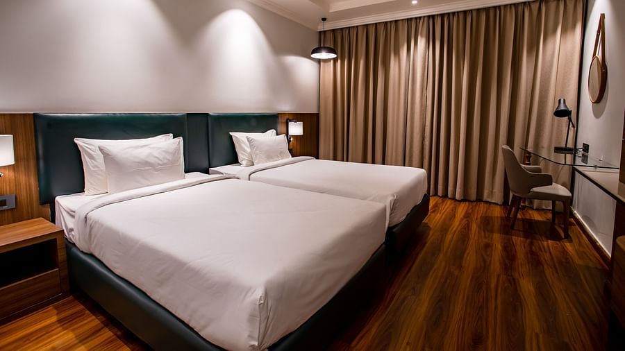 twin beds with side tables and lamps - The Wedlock Greens Hotel & Resort, Dhanbad