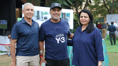 Smiling participants posing for a group photo at a daytime event on the hotel lawn.