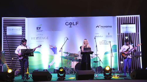 Live band performing at a golf-themed corporate event with elegant stage decor.