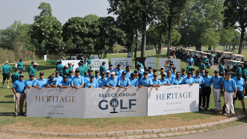 Large group of participants posing together at a corporate golf tournament outdoors.