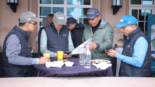 An image of a group of men enjoying their food together placed on a table at Heritage Village Resorts & Spa