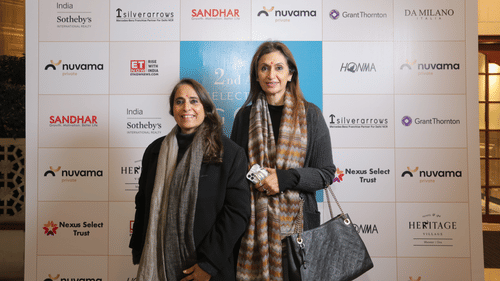 Two women posing in front of a sponsored brands board to Annual Golf celebration at Heritage Village Resorts & Spa
