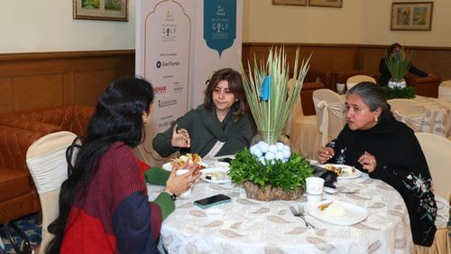 An image of three women sitting on a table and having food at an event in Heritage Village Resorts & Spa