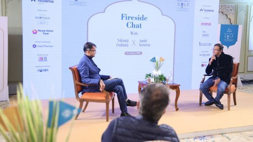 An image of two people sitting on a stage facing each other at an event in Heritage Village Resorts & Spa