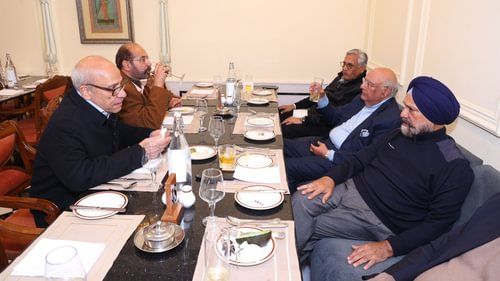 An image of elderly people gathered around the dining table with food at an event in  Heritage Village Resorts & Spa