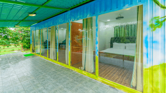 Covered entrance area of container rooms with glass doors and greenery at Nature Trails Durshet.