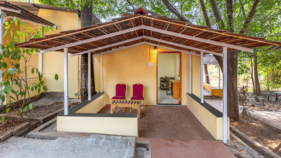 porch area with a ramp and a set of red chairs near the entrance.