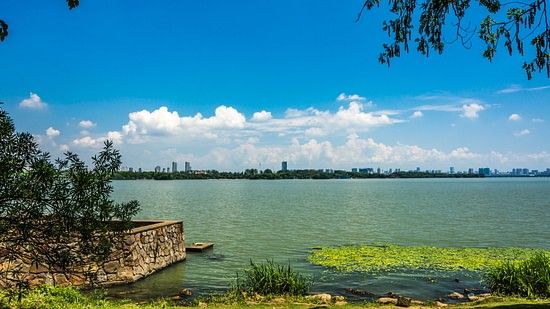 A tranquil waterway surrounded by lush vegetation, with boats gently gliding on the surface