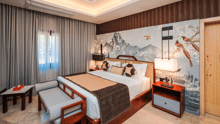 An overview of the Grand Suites in Jaipur at Ananta Resort & Spa, Jaipur, with side tables, lamps and a ceiling fan in view.