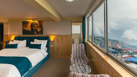 Image of a room with bed and seating area and large glass at Seven Seas