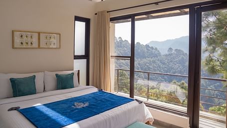 A  bedroom with pillows and a balcony at BluSalzz Escapade Resort, Lansdowne