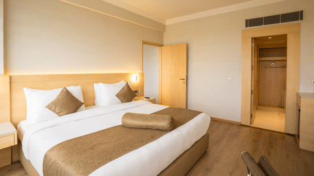 Suite at Gemini Continental featuring a bed with plush decorative pillows and a bolster, a ceiling fan, and a walk-in closet.