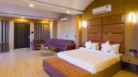 The Suite showcasing a double bed and the sofa area under a curved ceiling at Grassfield Riveria Resort.