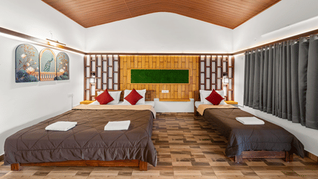 Spacious Family Room With Garden View 3 at Hatti Eden Coorg featuring one king size bed, one single bed, wooden accent wall, and contemporary interiors.