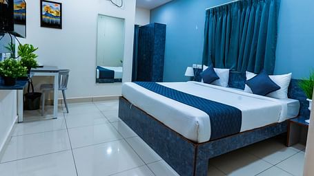 An image of a bedroom with king size bed, bedside table next to it, AC, flat TV screen, etc. - Hotel Aerotel, Hyderabad - A Unit of Comfort Hometel