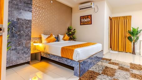 An image of a bedroom equipped with AC, wardrobe, and a table - Hotel Aerotel, Hyderabad - A Unit of Comfort Hometel