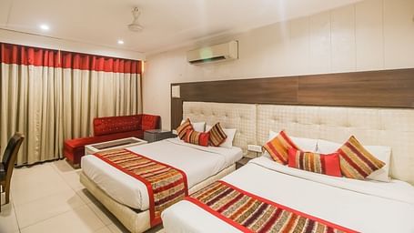 Family Room with two queen size beds and a seating area - Hotel Diamond Plaza, Chandigarh.