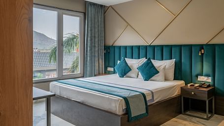 Stylish guest room featuring a comfortable bed and modern decor at Hotel Highway King Shahpura.
