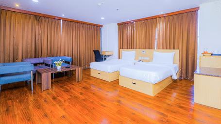 A spacious hotel room with 2 single beds, wooden flooring, and a comfortable seating area - Hyphen Business Hotel, Noida