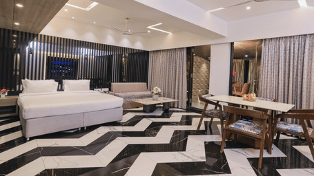 Suite with stylish interiors, living area, and television at Kumar Resort by Turtle.