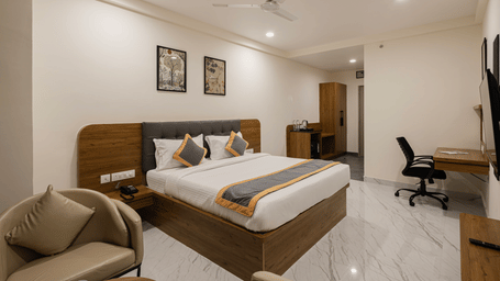 Well-furnished guest room with desk, chair, and king-size bed at Lemonridge Hotels, IDPL Balanagar.